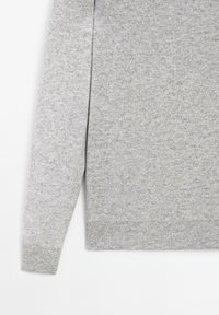 Szary sweter wykonany z dzianiny, z długimi rękawami, okrągłym dekoltem oraz ściągaczami przy mankietach i u dołu. Gładka faktura z minimalnym wzorem.