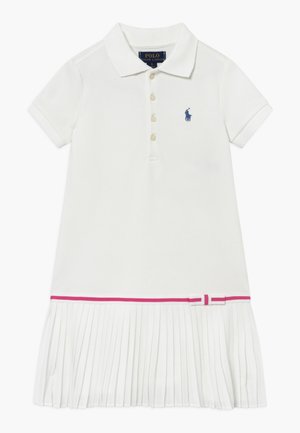 Robe polo blanche à manches courtes avec col boutonné, logo Polo Ralph Lauren bleu marine sur la poitrine, bordure rose et jupe plissée avec petit nœud.