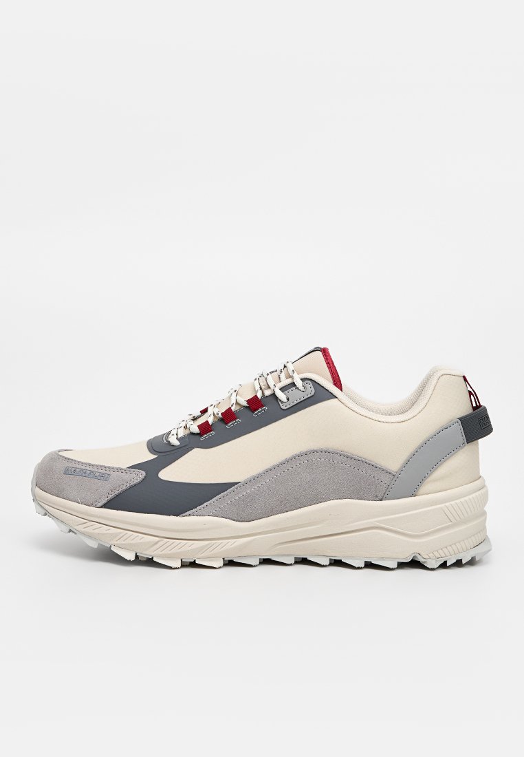 Des baskets présentent un dessus beige et gris avec une finition texturée, des lacets rouges, une pointe renforcée et une semelle épaisse et à motifs pour la stabilité.