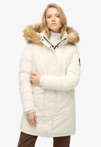 Hvid isoleret parka med en pelsforet hætte, der har lynlås- og trykknaplukning, to forlommer og en glat, glansfuld stoffinish.
