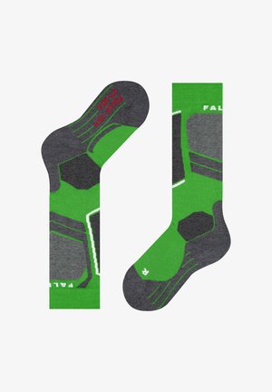 Calzini verdi e grigi con un motivo geometrico, maglia strutturata e tacco rinforzato. Include etichettatura rossa e bianca sulla suola.