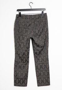 Pantalons à motifs foncés avec un design texturé de type damassé ; comprenant des poches arrière et une coupe droite, suspendus à un cintre noir.