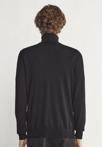 Schwarzer Strick-Turtleneck-Pullover, lange Ärmel, gerippte Bündchen und Saum, glatte Textur, figurnahe Silhouette, minimales Design, keine sichtbaren Muster.
