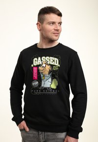 Černá mikina s potiskem v podobě karikatury v živých barvách, texty "Gazováno" a "Čistá věda" a volný střih.
