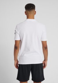 Witte polo shirt met korte mouwen en een minimalistisch ontwerp, voorzien van een klassieke kraag en een gladde, katoenen textuur.