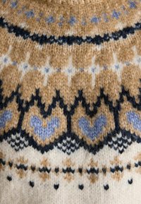 Strickpullover mit einem Fair-Isle-Muster in Beige, Marineblau und Hellblau. Strukturierte Wollzusammensetzung mit Herzmotiven und geometrischen Designs.
