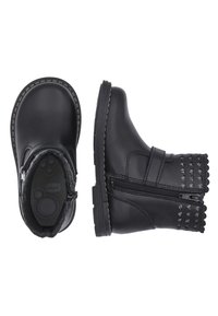 Botas de tobillo de imitación de cuero negro con punta redonda, cremallera lateral, borde decorativo en forma de ondas y acentos de tachuelas en el talón.