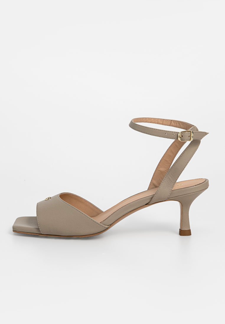 Sandale en cuir beige avec un bout ouvert, une fine bride de cheville et un talon stiletto de hauteur intermédiaire ; présente un design à bout carré et des détails subtils.