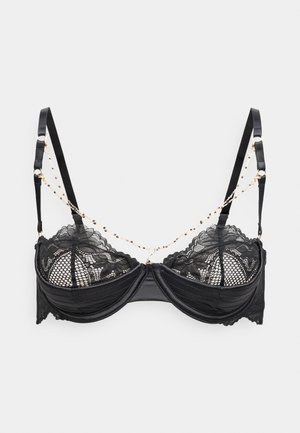 Črni čipkasti modrček z mrežastimi paneli, satenastimi skodelicami in nastavljivimi naramnicami. Okrašen z zlatim verižnim detajlom med naramnicami.