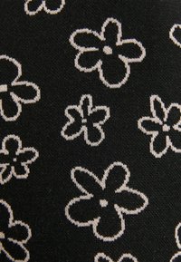 Černá látka s opakujícím se vzorem bílých obrysu květin. Textura je jemná a pletená, s konzistentním květinovým designem po celé ploše.
