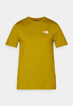 T-shirt a manica corta in cotone giallo senape con un logo bianco stampato sul lato sinistro del petto. Collo tondo con vestibilità standard e texture liscia.