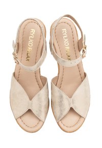 Béžové sandály s křížovým designem, vyrobené z texturované kůže, s nastavitelným páskem kolem kotníku a polstrovanou stélkou.