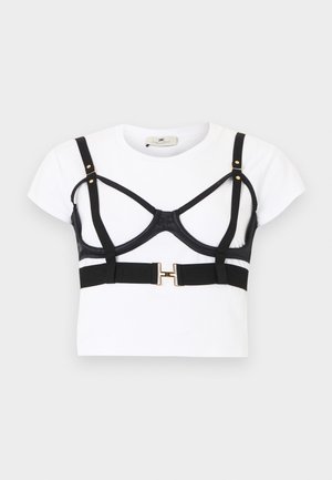 Hvid kortærmet crop top med sort selestylet bh-overlay med gulddetaljer og justerbare stropper.