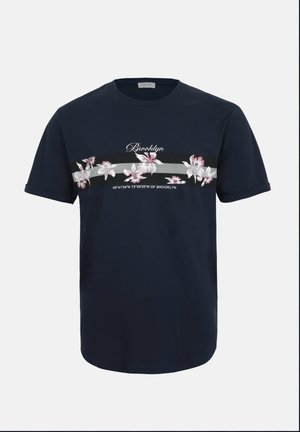 Camiseta azul marino de manga corta con el texto “Brooklyn”, una franja floral y coordenadas geográficas impresas en el pecho.