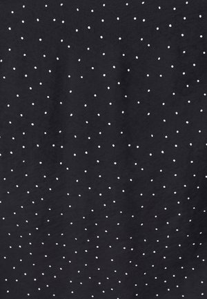 Tissu noir avec des petits pois blancs de manière irrégulière et des plis subtils.