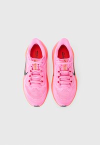 Baskets de course rose vif avec une tige en mesh, logo noir et accents orange. Dotées de six œillets et d'une semelle texturée pour une meilleure adhérence.