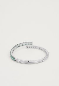 Bracelet jonc en métal argenté avec des gemmes claires et vertes alternées, présentant une finition lisse et un design ouvert pour un enfilage facile.