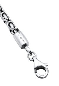 Verschluss aus Sterlingsilber mit Gliederkette und Karabinerhaken, gekennzeichnet mit einem Diamanten und "925" für Silberreinheit. Strukturierte und polierte Oberfläche.