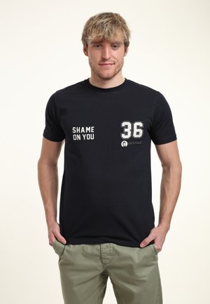 Černé bavlněné tričko s bílým textem "SHAME ON YOU" a číslem "36" na přední straně. Krátké rukávy, design s kulatým výstřihem.
