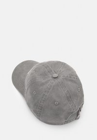 Casquette en coton grise avec un bord courbé, trous de ventilation cousus et une sangle réglable à l'arrière. Surface texturée avec une finition douce.