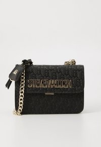 Black handbag with embossed logo pattern, gold-tone hardware, chain strap, and a front flap featuring a large "STEVE MADDEN" logo.