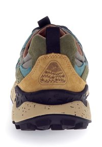 Vista posteriore di una scarpa da trekking multicolore con pannelli in suede verde, blu e marrone chiaro, un tab di trazione nero e una suola beige maculata e nera.
