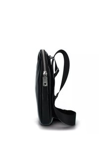 Borsa in pelle nera con una texture liscia, profilo sottile, chiusura con cerniera argentata e tracolla regolabile, presentata in vista laterale su uno sfondo bianco.