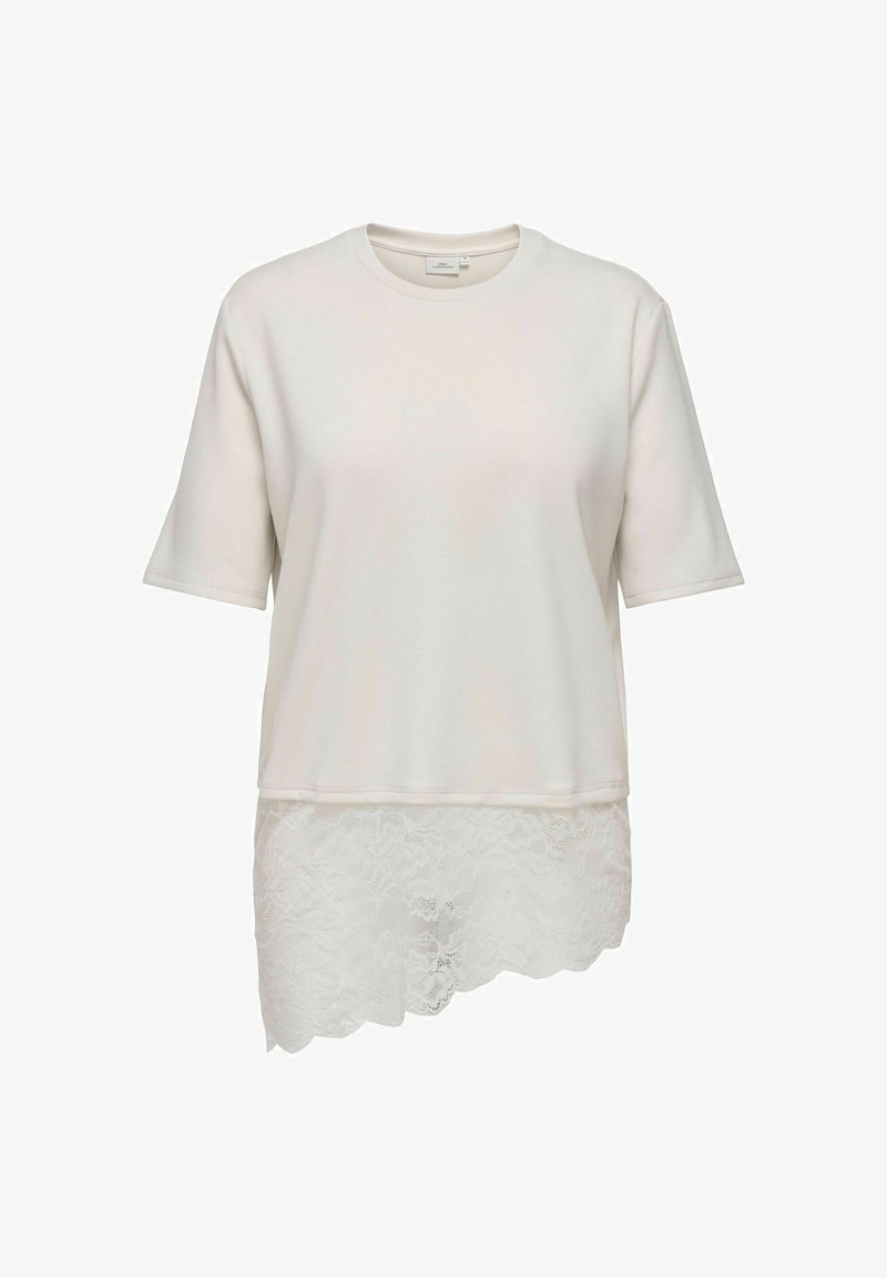 Haut blanc à manches courtes avec col rond et ourlet en dentelle asymétrique, plus long d'un côté.