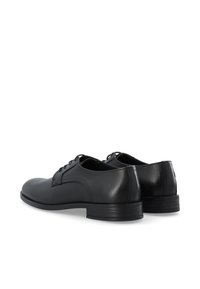 Chaussures de ville en cuir noir avec une finition lisse, bout arrondi et lacets. Le talon est bas avec une semelle en caoutchouc pour une meilleure adhérence.