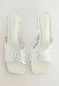 Sandales à glissière ouvertes en argent avec une tige texturée ornée de petites perles et de strass ; semelle intérieure de couleur claire unie et talon bloc.
