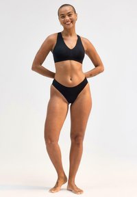 Reggiseno sportivo nero con design a V e bikini alto coordinato, caratterizzati da un tessuto morbido ed elastico e cuciture minime.
