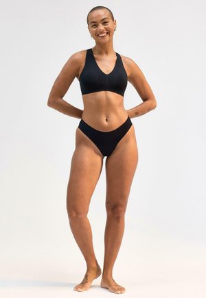 Sort sports-bh med V-hals design og matchende højtaljede bikiniunderdel, der har glat, strækbart stof og minimale sømme.
