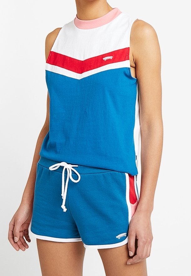 Haut bleu sans manches avec un motif chevron rouge et blanc ; short bleu assorti avec taille à cordon de serrage et accents sur les panneaux latéraux. Matière en coton.