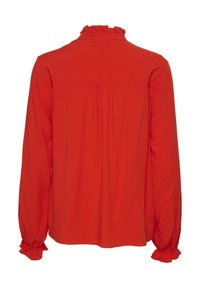 Red long-sleeve blouse with a ruffled collar. Smooth fabric, gathered detailing at the back, and elastic cuffs with ruffled edges.
