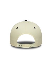 Cască snapback bej văzută din spate, cu ochiuri de ventilație negre și curea plastic ajustabilă, pe un fundal alb.