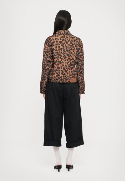 Prindi leopardimustriga jakk pruuni ja mustana, pikki varrukatega ning klassikalise kraega. Kombineeritud laia musta pükste ning rullitud varrukatega.