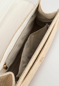 Borsa di paglia intrecciata con una patta in finta pelle di coccodrillo crema texturizzata. Presenta una chiusura magnetica e scomparti interni per l'organizzazione.