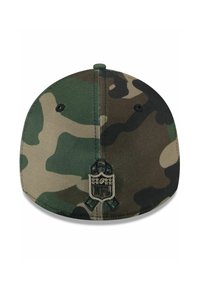 Casquette de baseball camouflée avec un motif vert foncé et marron, visière plate, et logo NFL brodé à l'arrière. Finition en tissu texturé.