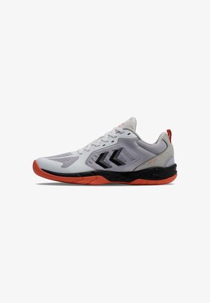 Chaussure de sport blanche avec logo chevron noir, panneaux en mesh, semelle noire et orange, et languette orange au talon, vue de côté sur fond blanc.