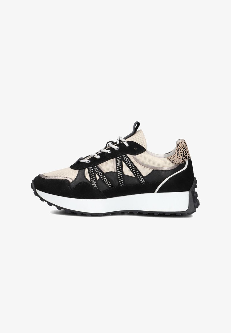 Zwart en beige sneaker van mesh en suede materialen, met witte veters, een dikke witte zool en een textuuraccent aan de achterkant.