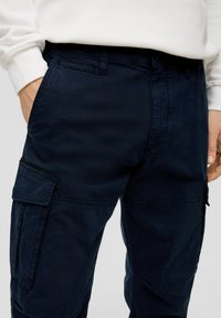 Marine cargo pants van stevige katoen met meerdere zakken, een ritssluiting en een relaxte fit. Glad textuur en duurzame stof.