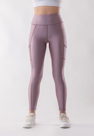 High-waisted, lavender leggings with a smooth texture, featuring side pockets and contrasting stitching details. Styled with white sneakers.