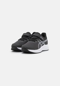 Baskets noires de sport avec une tige en mesh, accents blancs et un col rembourré. Système de fermeture double avec lacets et une sangle à boucle et crochets.