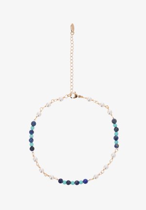 Hieno kultainen ketjurannekoru, jossa vuorottelevat valkoiset helmet, tummansiniset ja turkoosit pyöreät helmet. Rannekorussa on hummerilukko ja säädettävä jatkopala.