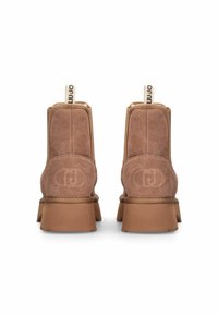 Stivaletti in suede marrone con suola in gomma piatta, forma arrotondata e linguetta con marchio. Sottile dettaglio logo impresso sul tallone.