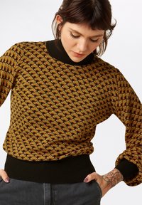 Pull en tricot avec un motif écaille doré-brun, col et ourlet côtelés noirs, manches longues avec des poignets froncés, tissu de poids moyen.