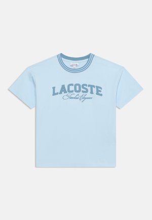 Lichtblauw T-shirt met korte mouwen, gestreepte kraag en geborduurde tekst "LACOSTE Timeless Elegance" over de borst.