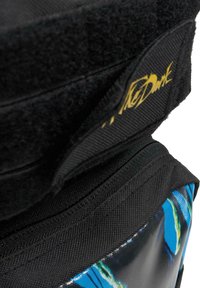 Svart ryggsäck med en strukturerad yta, som har ett färgglatt blått och grönt abstrakt mönster på sidan och en guldig logotypdetalj.