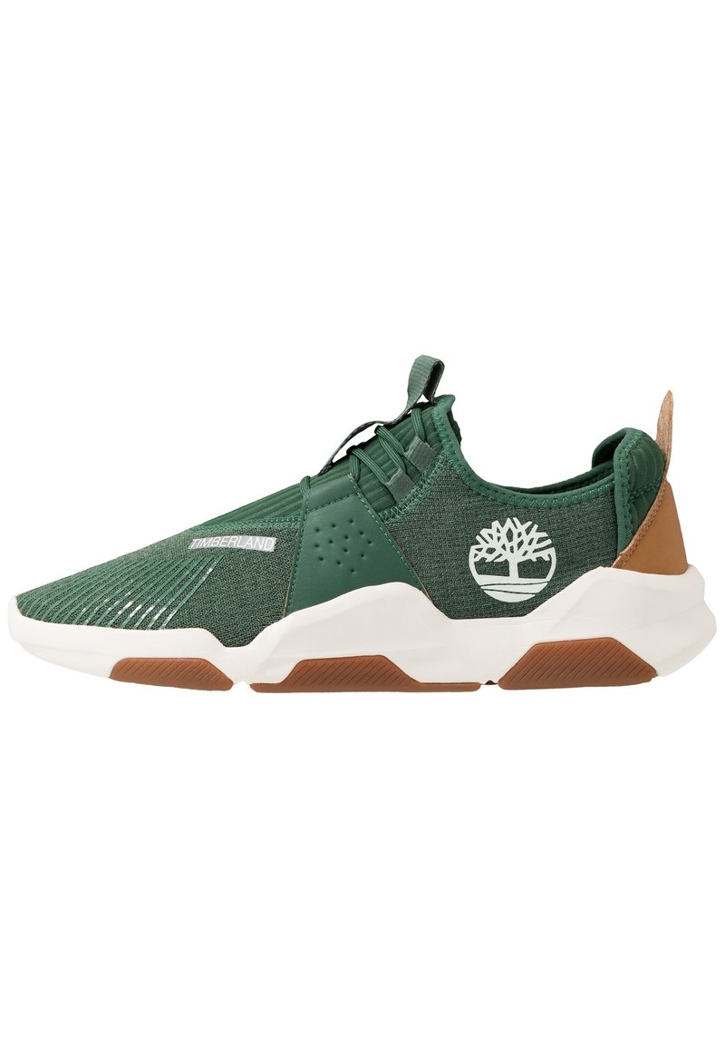 Baskets en textile vert avec semelle blanche, présentant un talon renforcé, des côtés perforés et le logo Timberland. Accent marron au talon.