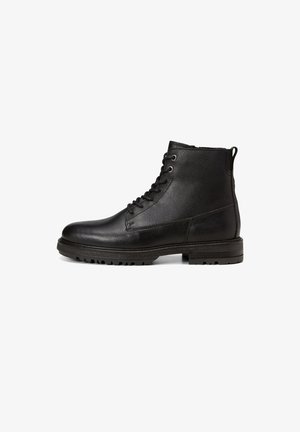 Bottines en cuir noir avec une finition texturée, des lacets, des œillets en métal ronds et une semelle robuste conçue pour une bonne adhérence.